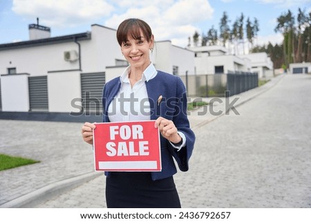 Woman in business suit has for sale sign in her hands