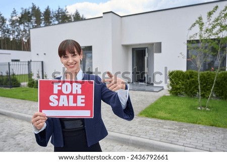 Realtor lady holds a for sale sign in her hands