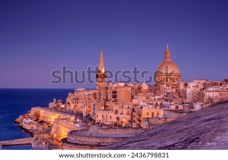 View from above of the golden dome of church and roofs with church of Our Lady of Mount Carmel and St. Paul's Cathedral in Valletta, Malta.