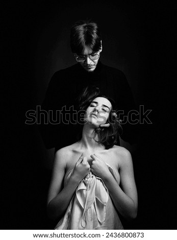 Conflict between partners in a relationship. Male violence. A girl and a guy quarrel, get divorced, scandal, betrayal. The woman is a victim. Black and white portrait.