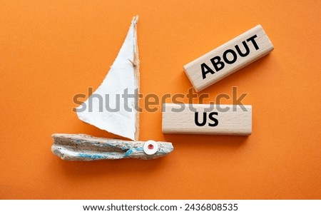 About us symbol. Concept word About us on wooden blocks. Beautiful orange background with boat. Business and About us concept. Copy space