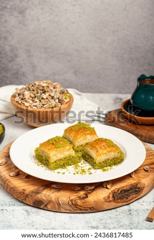 Baklava with pistachios on a wooden background. Turkish cuisine delicacies. Ramadan Dessert. local name kuru baklava Royalty-Free Stock Photo #2436817485