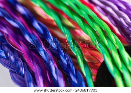 Colored braids, hair accessory on an elastic band background close-up.