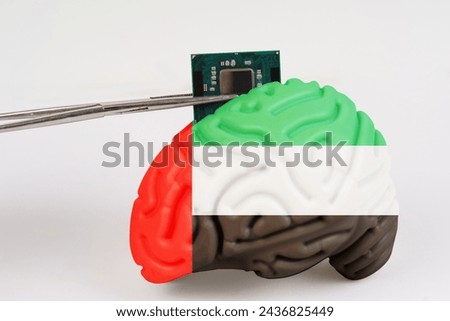 On a white background, a model of the brain with a picture of a flag - UAE, a microcircuit, a processor, is implanted into it. Close-up