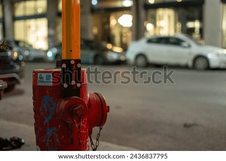 Red fire hydrant with graffiti on side of road near building - 4449 Boul. Saint-Laurent, Montreal, QC H2W 1Z8, Canada Royalty-Free Stock Photo #2436837795