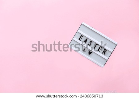 Happy Easter led sign. Lightbox with text Easter on pink background. Concept Easter style. Creative composition Flat lay.  Greeting card. Top view 