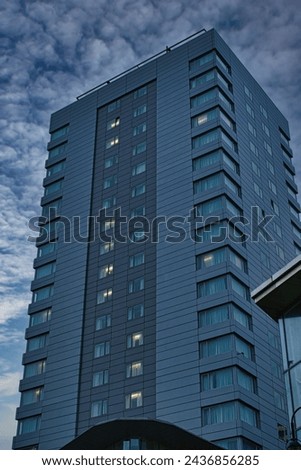 Modern high-rise building against a cloudy sky at dusk in Leeds, UK.