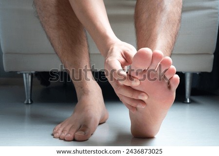 Man, foot pain and cramps in legs and ankles from Plantar Fasciitis disease Be relieved the pain with the soles of his feet. Royalty-Free Stock Photo #2436873025