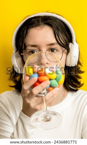 A teenage girl holds a wine glass with Easter eggs.