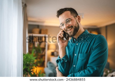 One adult man with eyeglasses stand at home use mobile phone talk Royalty-Free Stock Photo #2436884855