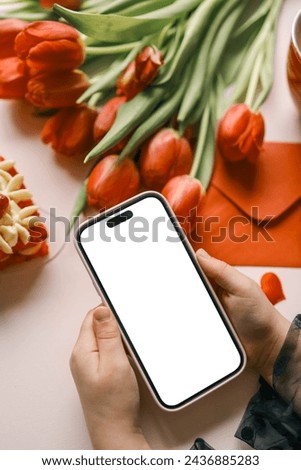 Girl with a phone in her hands with an isolated screen on a background of flowers.