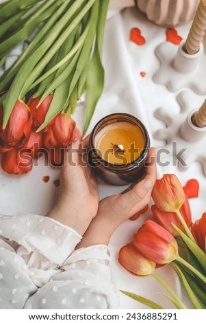 A girl holds a candle in her hands, spring mood.
