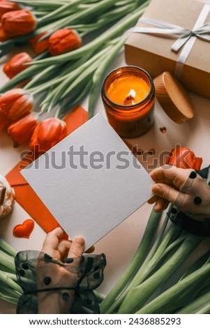 Sheet of paper in hands on a background of spring flowers.