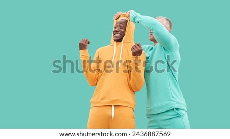 Multi ethnic friends. Two men different color black African-American ethnicity and white Caucasian ethnicity standing isolated green background. Dressed active sportswear. interracial friendship Royalty-Free Stock Photo #2436887569