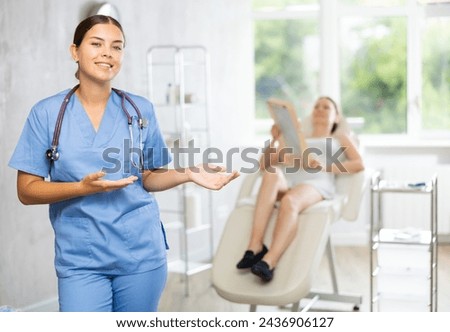 There is medical employee in hospital office. Unrecognizable patient sitting in chair in background. Private outpatient practice. Individual approach to treatment Royalty-Free Stock Photo #2436906127