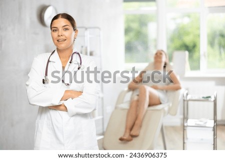 There is medical employee in hospital office. Unrecognizable patient sitting in chair in background. Private outpatient practice. Individual approach to treatment Royalty-Free Stock Photo #2436906375