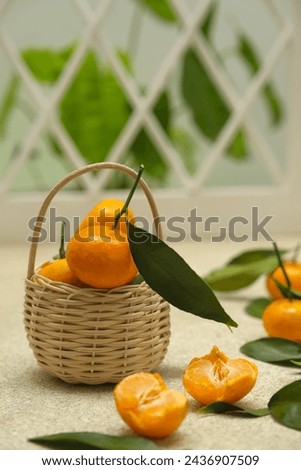 Small oranges fruit or tangarine in rattan basket with brown background. Jeruk Royalty-Free Stock Photo #2436907509