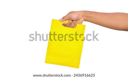 hand holding yellow bag at isolated white background