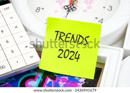 The evaluation methods, popular topics, and new trends in business. TRENDS 2024 written on a yellow sticker near the calculator and the clock