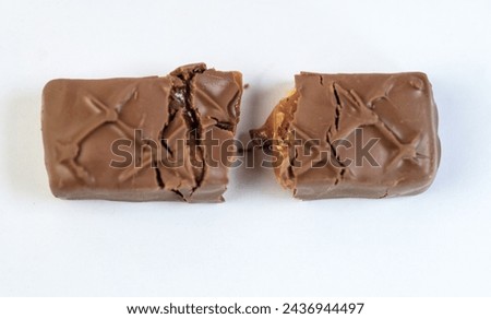 A single chocolate bar, bathed in warm light with a blurred background