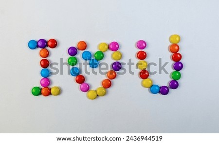 Playful candy letters in a rainbow of colors spell out "I love you" on a white background