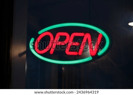 Bright neon electric OPEN sign in a window