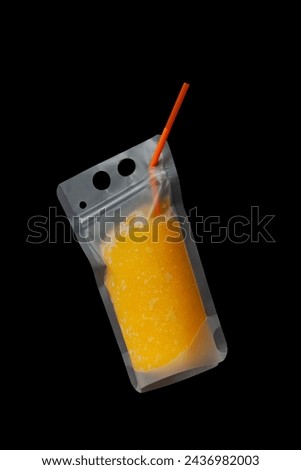 Orange Slush or Granizado in leak-proof plastic drink pouch on dark background. Refreshing summer drink. Fruits iced slushie or Sweet citrus shaved ice. Convenient package take away. Royalty-Free Stock Photo #2436982003