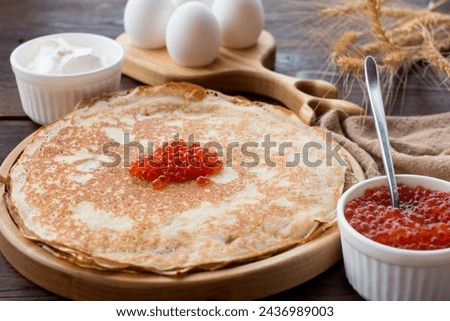 Maslenitsa holiday, pancakes with red caviar and sour cream on the table. The Russian tradition