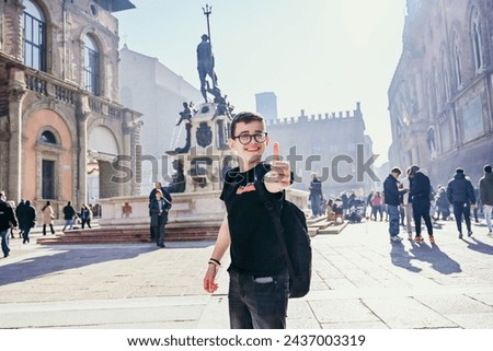 Happy smiling boy during language vacation.at the center of Bologna . Concept of traveling famous landmarks in Italy. Caucasian  Boy tourist   m