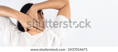 Stressed blonde woman massaging red sore neck, back view, black and white photo, studio background, copy space. Neck pain muscle stress and strain concept. 