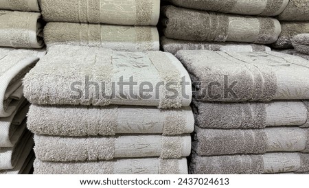 Stacks of folded bath towels. Beige cotton terry towels on the shelf