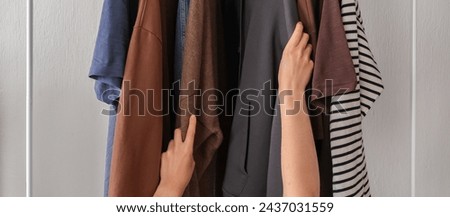 Spring cleaning,second hand,Fast fashion, the girl puts things in order in the closet. A bunch of colorful clothes. The concept of processing, second hand, eco, minimalism, consumption of goods Royalty-Free Stock Photo #2437031559