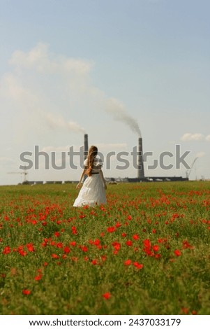 A girl in a white dress and long brown hair walks through a poppy field