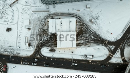 Drone photography of directly above petrol station and tire imprints during winter cloudy day