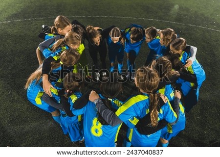 high angle view of little girls standing in a circle and talking about the strategy before match. High quality photo Royalty-Free Stock Photo #2437040837