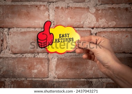 Easy Returns. Sticky note with text on a red brick background.