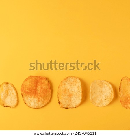 Crispy potato chips on yellow background, flat lay. Space for text