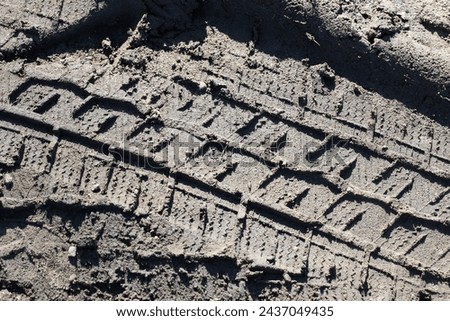 Sand tyre mark background. Tire track shape. Trail lines on dry brown sand pattern. Road construction site backdrop. Heavy machinery imprint. Dried mud vehicle wheel shape.