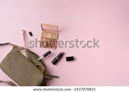Women's things fall out of a bag on a pink background