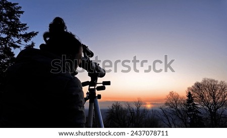 Amateur astronomer observing Sun eclipse and Sun with a telescope and special solar filter. Royalty-Free Stock Photo #2437078711