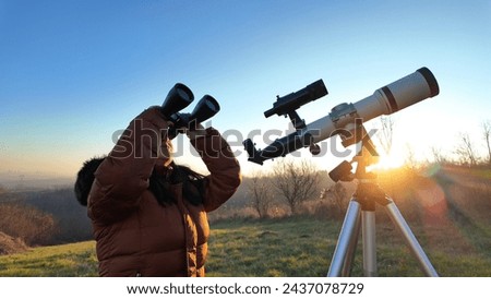 Amateur astronomer observing skies with a telescope and binoculars. Royalty-Free Stock Photo #2437078729