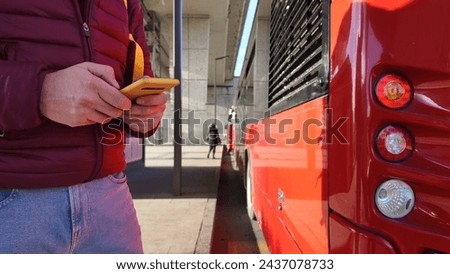 Commuter waiting for a bus at city station. Royalty-Free Stock Photo #2437078733