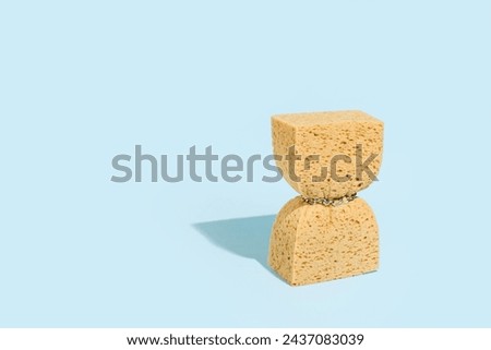 
A washing sponge squeezed with a chain, minimal creative concept, body care, weight loss, obesity. Royalty-Free Stock Photo #2437083039