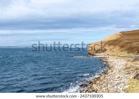 Scenic cliffs near Dunnet Head, in Caithness, on the north coast of Scotland, the most northerly point of the mainland of Great Britain. Dwarwick Pier at high tide in the center. Royalty-Free Stock Photo #2437100305