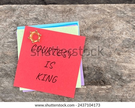 Courtesy is king written on red notepaper with retro background. Stock photo.