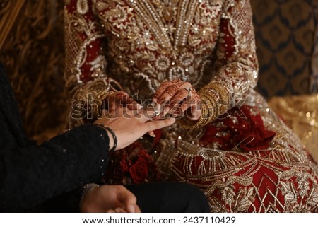 In this captivating image, the hands of a bride and groom are delicately clasped together, embodying the timeless union of love and commitment. Their intertwined fingers convey a sense of intimacy 