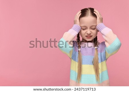 Little girl suffering from headache on pink background. Space for text