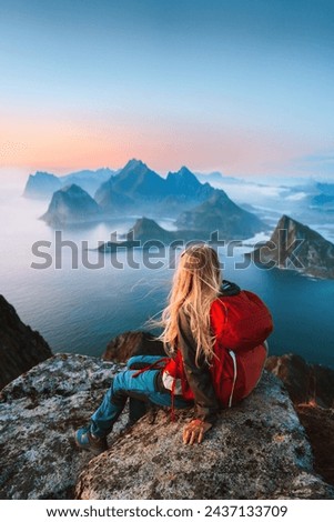 Woman traveler hiking in Norway girl backpacker relaxing on mountain cliff edge in Lofoten islands female tourist traveling outdoor alone healthy lifestyle summer vacations adventure trip  Royalty-Free Stock Photo #2437133709