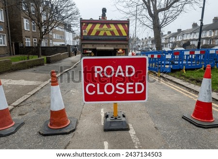 A road closed to traffic as a result of highway maintenance with a road closed sign and traffic cones.