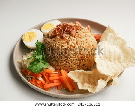 Fried rice is served with boiled eggs, carrot salad, tomatoes and crackers, with a flat lay concept